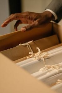 Close-Up Shot of a Person Holding a Box of Files